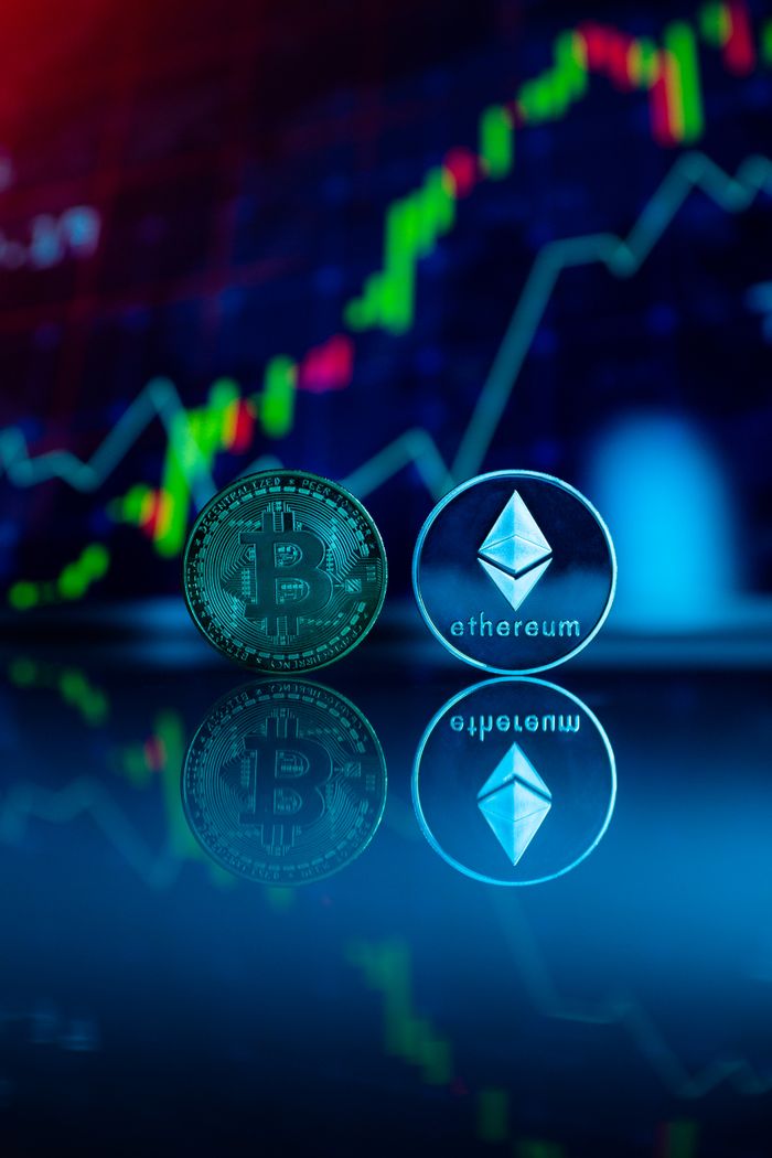 Conceptual image of Bitcoin and Ethereum coins reflecting stock market graph for cryptocurrency trading.